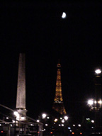 the eiffel tower and the egyptian obelisk with the full moon behind them